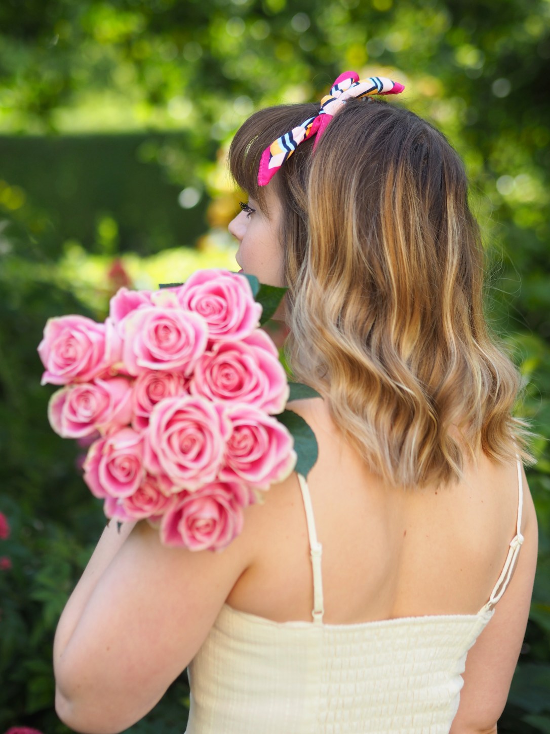 Girl in strappy dress holding roses