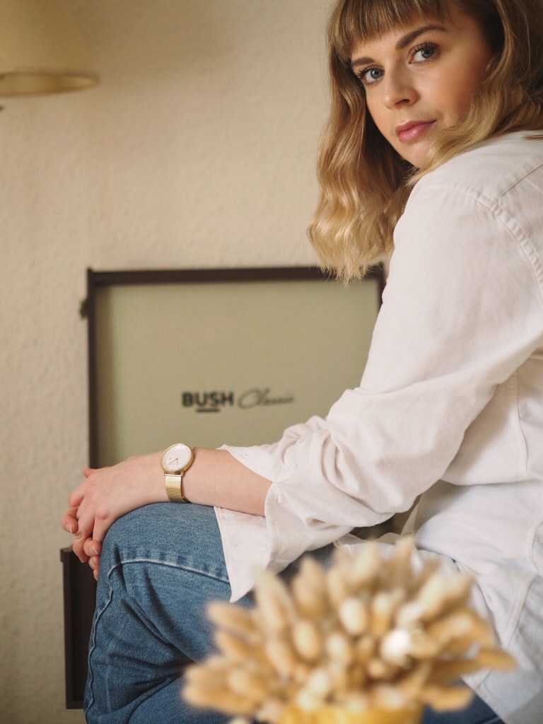Elevated basics outfit of blue jeans, oversized white shirt and gold details